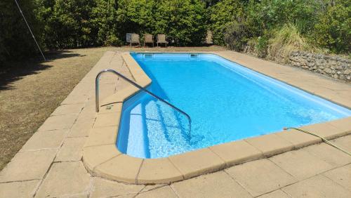 een zwembad met een metalen rail in een tuin bij Mas Ca La Coixa in Tortellá