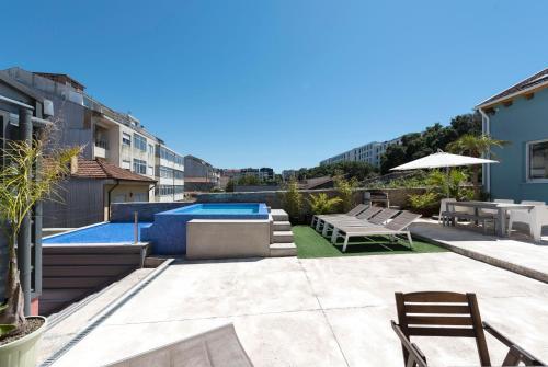 un patio trasero con piscina y muebles de exterior en Fred's House Asprela en Oporto