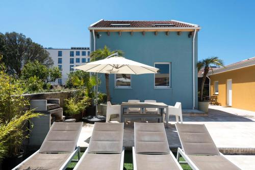 une terrasse avec une table, des chaises et un parasol dans l'établissement Fred's House Asprela, à Porto