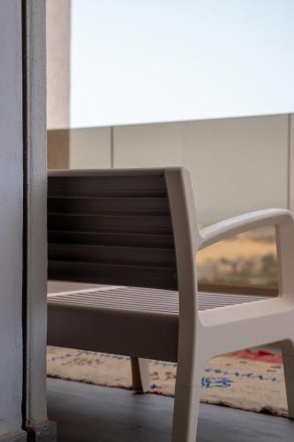 a white bench sitting in front of a window at Tayyurt Surf Camp Tamraght Aourir in Awrir