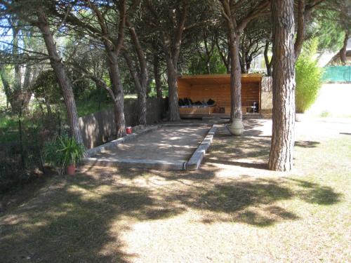 un parc avec un banc sous une bande d'arbres dans l'établissement Villa Aureliana, à Saint-Raphaël