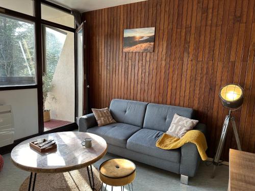 un salon avec un canapé bleu et une table dans l'établissement Appt pied des pistes 53m2 -5pers, à La Bresse