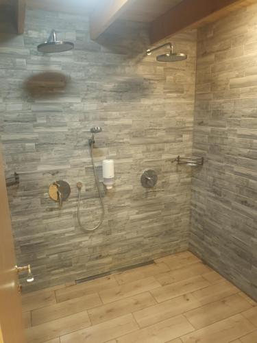 La salle de bains est pourvue d'une douche et d'un mur en pierre. dans l'établissement Varbla sadam ja restoran Groot, 