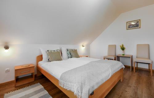 a bedroom with a large bed and two chairs at B&B Plitvica Falls House in Plitvica selo