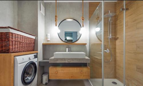 een badkamer met een wastafel en een wasmachine bij NADMORSKI NAVIO APARTMENT PRZY PLAŻY in Gdańsk