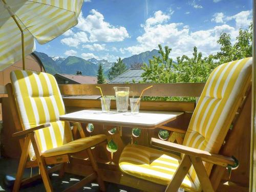 2 Stühle und ein Tisch mit Getränken auf dem Balkon in der Unterkunft Haus Sylvest in Oberstdorf