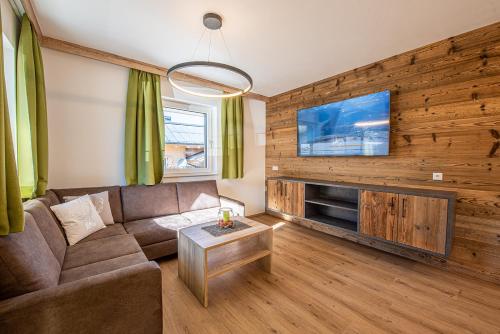 uma sala de estar com um sofá e uma televisão de ecrã plano em AppartMO - Zillertal Arena, Hohe Tauern, Salzburgerland, Krimml, Hochkrimml em Krimml