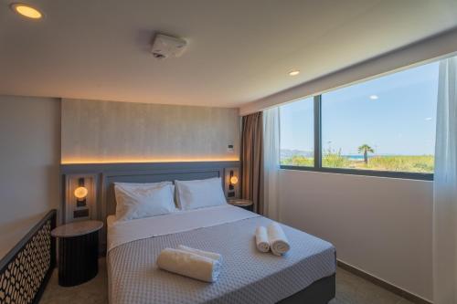 - une chambre avec un lit et 2 serviettes dans l'établissement EcoHeaven Suites, à Amoudara