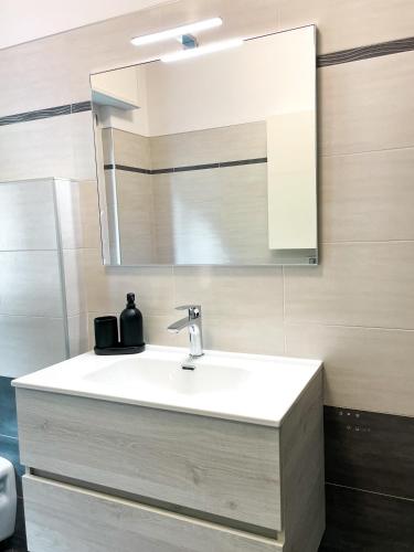 a bathroom with a white sink and a mirror at Due Pini Apartment - Ponte Caffaro Lake Idro in Ponte Caffaro