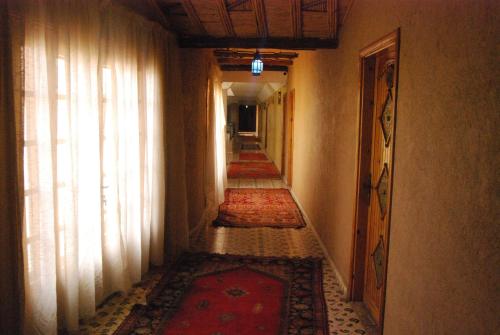 an empty hallway with rugs on the floor and a hallway with a hallwayngth at Hotel Taddart in Midelt