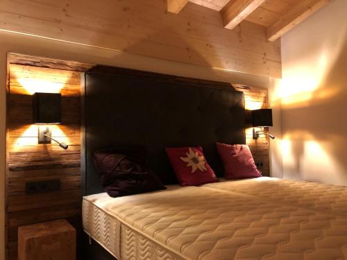 Filzstein Resort Chalet - Zillertal Arena, Hohe Tauern, Salzburgerland, Krimml, Hochkrimml في كريمل: غرفة نوم بسرير مع جدار خشبي