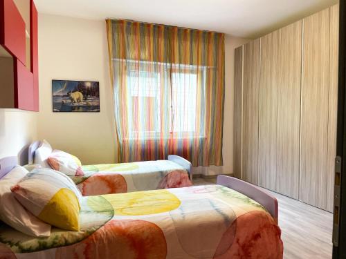 a hotel room with two beds and a window at Due Pini Apartment - Ponte Caffaro Lake Idro in Ponte Caffaro