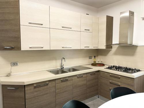 a kitchen with wooden cabinets and a sink at Due Pini Apartment - Ponte Caffaro Lake Idro in Ponte Caffaro