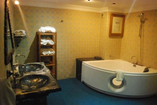 a bathroom with a bath tub and a sink at Hotel Taddart in Midelt