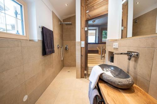 La salle de bains est pourvue d'un lavabo en pierre sur un comptoir en bois. dans l'établissement Filzsteinresort Chalets Chalet Bergankunft 236, à Krimml