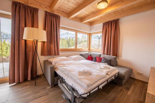 克里姆尔Filzsteinresort Chalets - Chalet 239的一间带床和大窗户的卧室