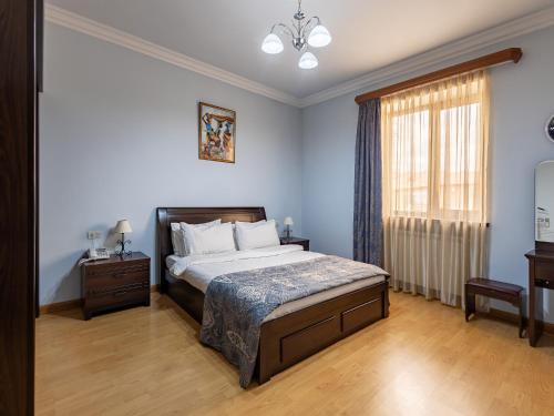 a bedroom with a large bed and a window at La Defense Hotel Yerevan in Yerevan