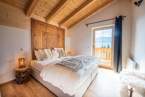 a bedroom with a large bed with a large window at Filzsteinresort Chalets - Chalet 237 in Krimml