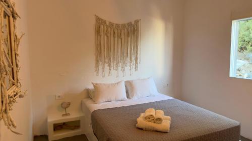 sypialnia z łóżkiem z dwoma ręcznikami w obiekcie Prickly Pear House w mieście Plaka Milou