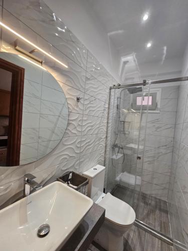 y baño con ducha, aseo y lavamanos. en Fotini's Apartments - Pelekas Beach, en Pelekas