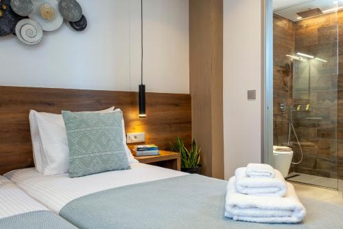 1 dormitorio con 1 cama con toallas en FYSIOPHYLIA VILLAS, en Frangokastello