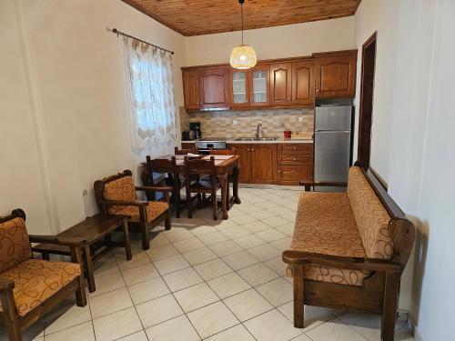 una cocina con armarios de madera, mesa y sillas en Fotini's Apartments - Pelekas Beach, en Pelekas