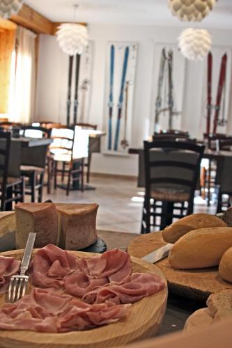 a table with bread and meat on top of it at Residence Les Coupoles in Champoluc