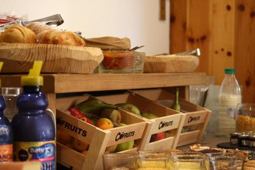 a table with boxes of fruit and bread and bottles at Residence Les Coupoles in Champoluc