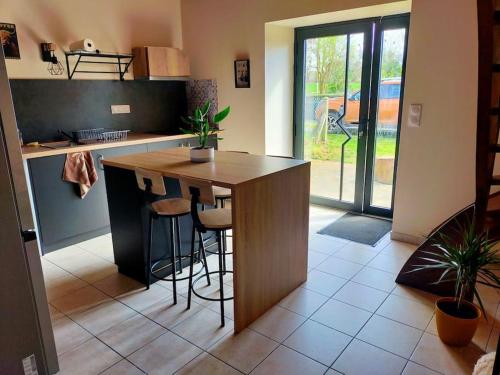 a kitchen with a wooden island in the middle of a room at Maison au calme bord de mer in Jullouville-les-Pins