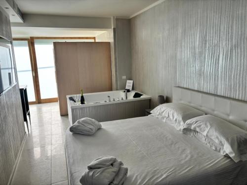 a bedroom with a large bed and a bath tub at Catania Sea Palace Hotel in Catania