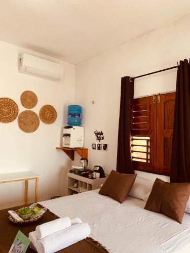 a bedroom with a bed with a window and a microwave at Suite casal na praia do Preá in Cruz