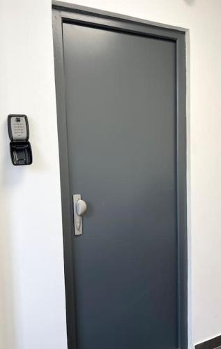 une porte avec une horloge sur son côté dans l'établissement Cosy studio aux portes de Paris, à Bagneux