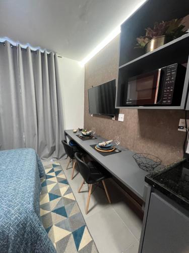 um quarto com uma cama e uma secretária com um micro-ondas em Studio America Gardens no Rio de Janeiro