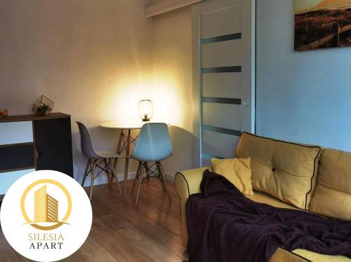 a living room with a couch and a table at Apartament Lancelot in Tychy