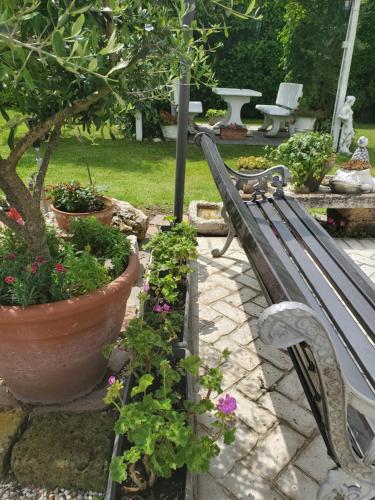 a park bench in a garden with flowers at Casacobelli in Monzambano