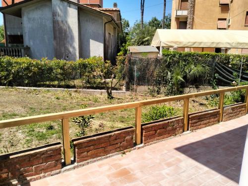 a wooden fence in front of a yard at Appartamento Eusepia, Locazione Turistica Tirrenia in Tirrenia