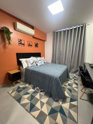 um quarto com uma cama, uma secretária e uma janela em Studio America Gardens no Rio de Janeiro