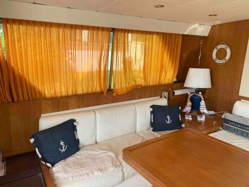 a living room with a white couch and a wooden table at NUIT EXCEPTIONNELLE SUR UN SUPERBE BATEAU Yacht ! in Empuriabrava