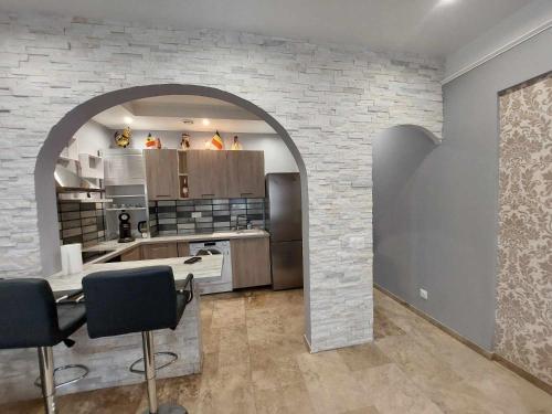 a large kitchen with an archway in a house at Charmant appartement avec Terrasse in Tarascon