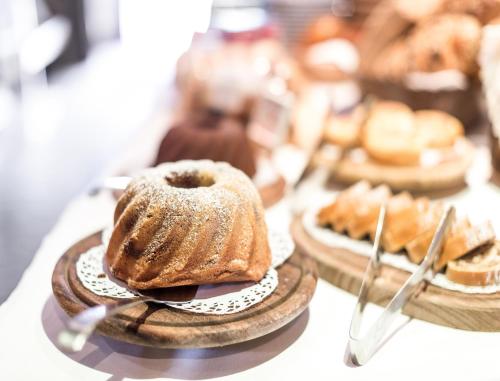 a table topped with plates of pastries on plates at Salzburg Hotel Holznerwirt in Eugendorf