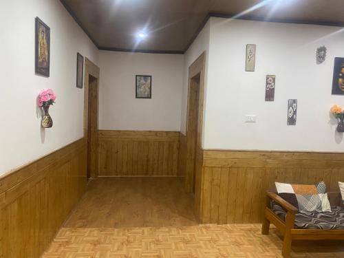 a hallway with wooden floors and a room with a bench at Jimmys homestay in Leh