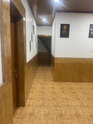 an empty hallway with an open door and a staircase at Jimmys homestay in Leh