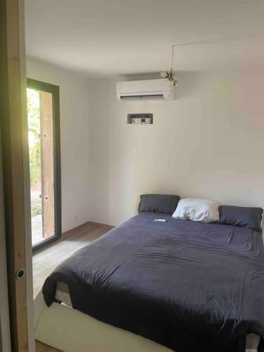 une chambre avec un lit dans une pièce avec une fenêtre dans l'établissement Villa avec piscine et place de parking proche centre ville, à Aix-en-Provence