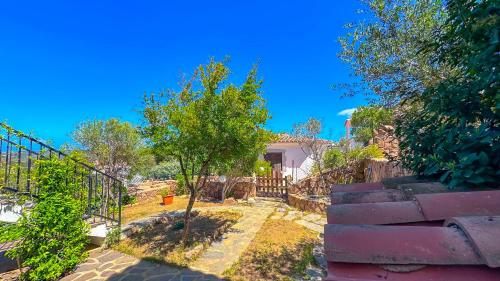 a house with a staircase and a tree in the yard at Appartamento Porta del Vento 2 in Porto San Paolo
