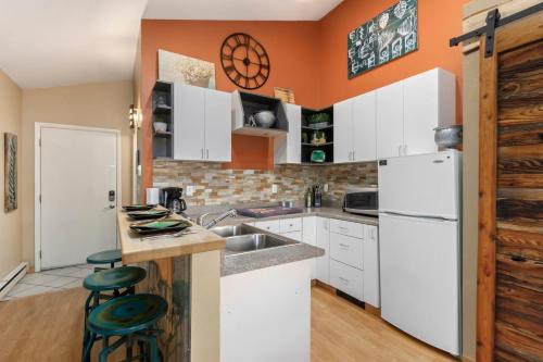 Industrial Old Town Bungalow with Free Cruiser Bikes في فورت كولينز: مطبخ مع دواليب بيضاء وجدار برتقالي