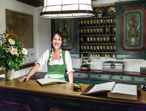 a woman sitting at a table in a bar at Salzburg Hotel Holznerwirt in Eugendorf