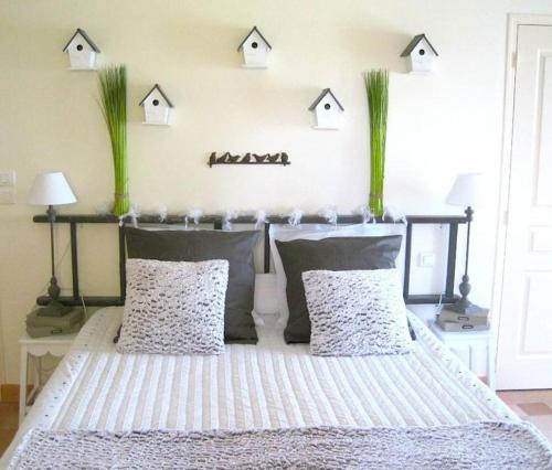 une chambre avec un lit avec deux oreillers et des maisons sur le mur dans l'établissement Grand gîte, campagne, piscine et spa - Saumur, à Blou