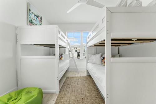 1 Schlafzimmer mit 2 Etagenbetten und einem Sofa in der Unterkunft Beach House - Whale Rested by Panhandle Getaways in Panama City Beach