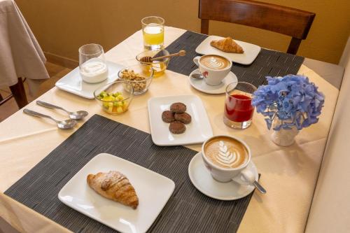 a table topped with plates of food and cups of coffee at Salamureci Camere in Trapani