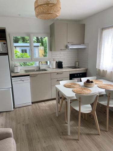 - une cuisine avec une table, 2 chaises et un évier dans l'établissement Maisonnette avec jardin, à Domont